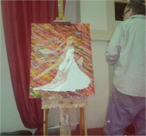 Are we showing grace to one another?  To ourselves?  Photo of artist painting white robed female warrior on a brightly coloured background at All Nations Church Leicester as part of the service